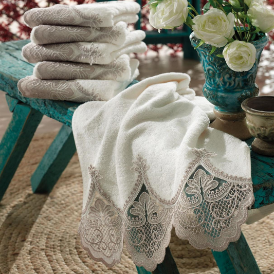 Luxurious room designed with a green table,  flowers and ecru color Turkish hand towels which are ornamented with bronze color French lace